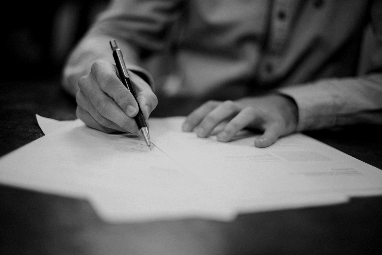 A buyer signing a trade contract at a desk